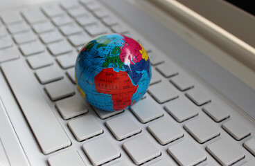 Closeup View Of Globe Model Lying On A Clean Empty Keys Of Computer Keyboard. Global Solutions Concept Stock Image 
