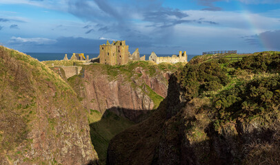 Mixed weather giving a slight rainbow at Dunnottar Castle near Stonehaven in Aberdeenshire, Scotland.