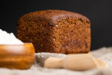 a square dark loaf of bread on the table