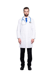 Full size portrait of attractive, concentrated virile harsh doc with beard in white lab coat, tie and stethoscope on his neck, looking at camera, isolated on grey background