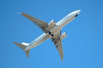 A modern airliner soaring gracefully through a clear blue sky.