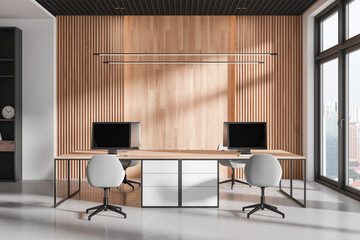 Modern workspace interior with pc monitors on tables, panoramic window - obrazy, fototapety, plakaty