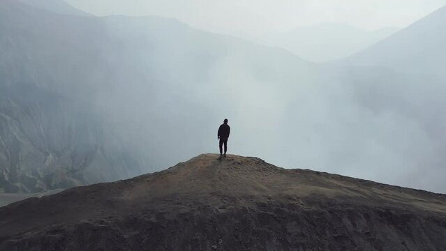 Man stands cliff volcano crater