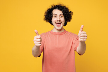 Young smiling satisfied cool fun happy man he wear pink t-shirt casual clothes showing thumb up...