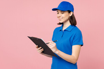 Professional fun delivery girl employee woman wear blue cap t-shirt uniform workwear work as dealer courier hold clipboard with papers sign document isolated on plain pink background. Service concept.