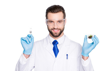 Portrait of attractive biologist in white outfit with tie, showing having forceps and vial with...