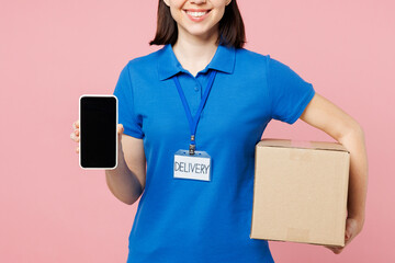 Close up delivery employee woman wear blue cap t-shirt uniform workwear work as dealer courier hold cardboard box use blank screen mobile cell phone isolated on plain pink background. Service concept. - 791453747