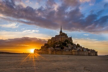 Classic view of famous Le Mont Saint-Michel tidal island in beautiful evening twilight at sunset,...