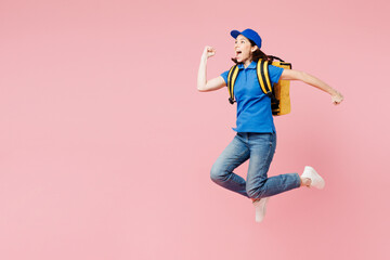 Full body delivery employee woman wears blue cap t-shirt uniform workwear yellow thermal food bag backpack work as dealer courier jump high run fast isolated on plain pink background. Service concept.