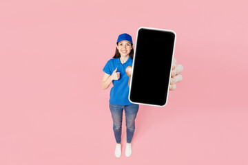 Full body happy delivery girl employee woman wear blue cap t-shirt uniform workwear work as dealer courier hold use blank screen mobile cell phone isolated on plain pink background. Service concept. - 791453791
