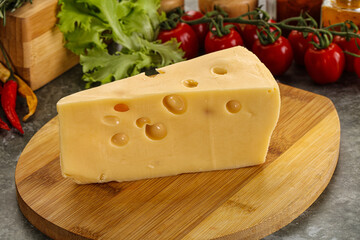 Swiss Maasdam cheese triangle over board