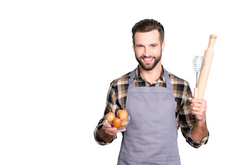 Portrait with copyspace, empty place for advertisement of attractive cheerful cook is ready to make some meal, having showing equipments, standing over grey background