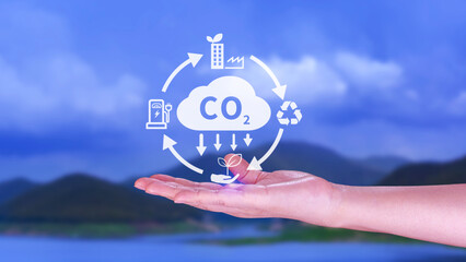 Hand holding CO2 reducing virtual icon for decrease carbon dioxide emission, carbon footprint and carbon credit to limit global warming from Bio climate change concept. - obrazy, fototapety, plakaty