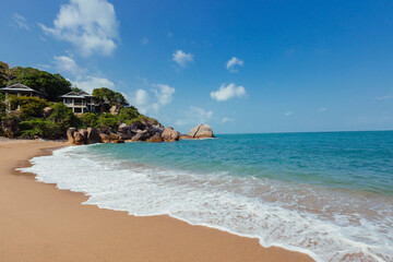 Sandy beach stretching along the ocean, with houses visible in the background