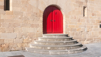 Puerta de madera pintada de rojo en arco de fachada de palacio - Powered by Adobe