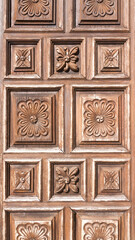 Casetones de madera decorados con tallas floreales en puerta de palacio antiguo