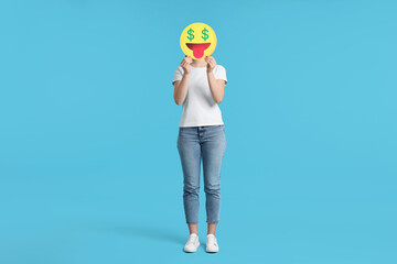 Woman covering face with dollar signs instead of eyes on light blue background