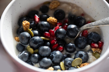 CLOSE UP HEALTHY BREAKFAST PORRIDGE WITH BERRIES AND SEEDS SPOON JUST SEEN 