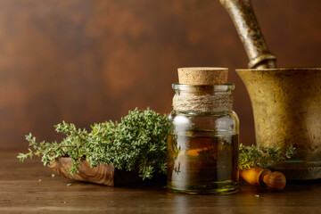Bottle of thyme essential oil with fresh thyme.