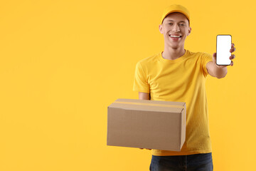 Happy courier with parcel and smartphone on orange background. Space for text