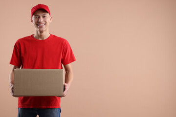Happy courier with parcel on beige background. Space for text