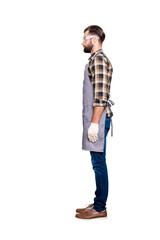 Full size body snap, half face side view portrait of attractive calm carpenter with hairstyle in safety glasses, jeans, isolated grey background