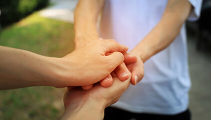 Couple  hand as lending a helping hand as trust together with compassion concept as lens flare scene at park