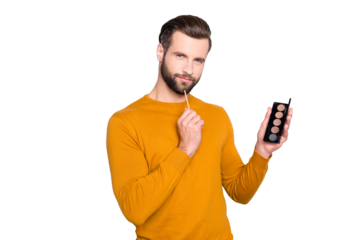 Portrait of ponder minded dreamy visagist in pullover with hairstyle having palette of shadow in hand, looking at camera isolated on grey background