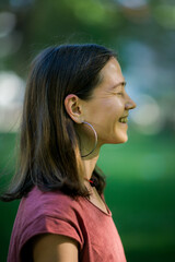 Profile with a smile: A woman beams brightly in profile, her smile radiating warmth and positivity.