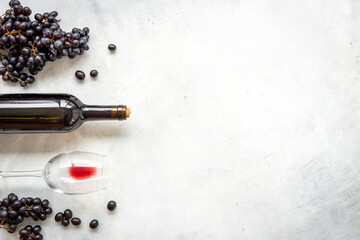 Bottle of red wine with bunch of grapes and wineglass