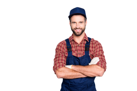 Portrait of handsome mechanic with stubble in blue overall, shirt having his arms crossed, looking at camera, isolated on grey background