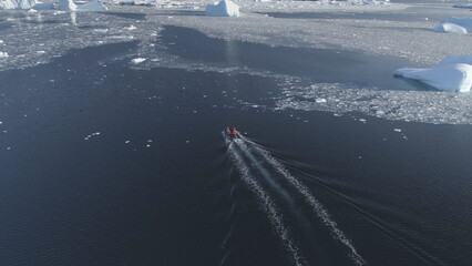 Zodiac Boat Sail Antarctica Aerial Tracking. Drone Flight Overview of South Pole Ocean Landscape. Rubber Boat Float in Winter Open Water Brash Ice. - obrazy, fototapety, plakaty