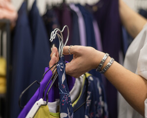 Close-up of woman's hands with hangers in a clothing store. 