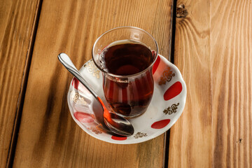 Traditional Turkish Tea Served in Glass Teacup with Saucer and Spoon, Hot Beverage on Wooden Surface
