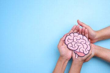 People hands holding human brain cutout paper. Health or pathological condition of human brain,...