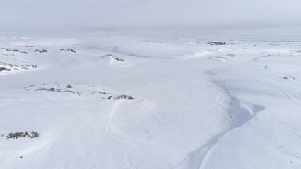 Snowmobile Drive on Snow Arctic Majestic Landscape. Drone Flight of Ski-doo Rider in Nature Winter...
