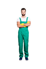 Full size fullbody portrait of attractive strict cleaner with stubble wearing green uniform, shoes,...