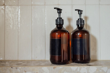 Close-up layouts with brown plastic bottles with dispensers in the bathroom. Mock-ups of shampoo or...