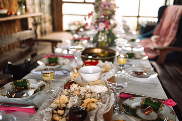Festive dinner banquet to the restaurant. Table with delicious food. Close-up of sliced cheese and tomatoes. No people.