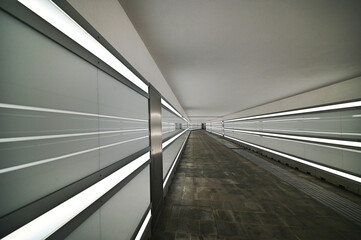 perspective view of a long illuminated underpass almost deserted