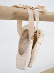 Ballerina gracefully poised at the ballet barre in a sunlit studio, practicing her pirouettes and...