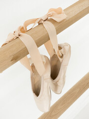 Ballerina gracefully poised at the ballet barre in a sunlit studio, practicing her pirouettes and...