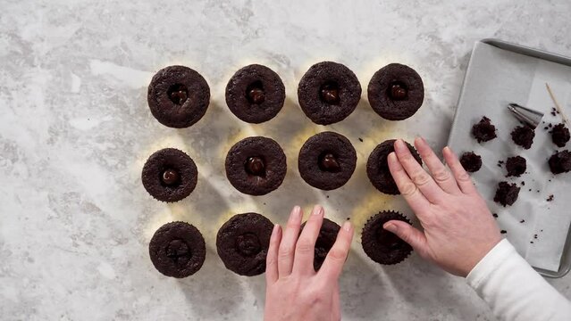 Time lapse. Flat lay. Filling in chocolate cupcakes with chocolate ganache.