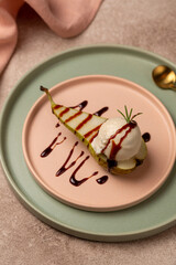 A ball of craft natural ice cream with gorgonzola cheese flavor on half a pear