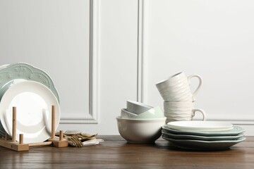Beautiful ceramic dishware, cups and cutlery on wooden table