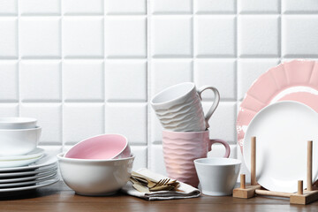 Beautiful ceramic dishware, cups and cutlery on wooden table