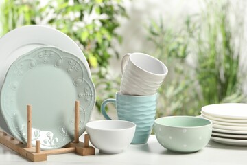 Beautiful ceramic dishware and cup on white table outdoors