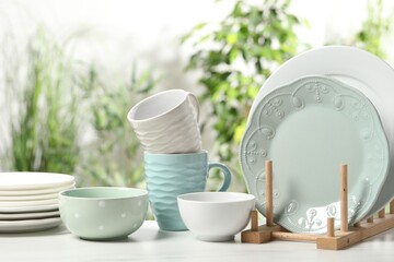 Beautiful ceramic dishware and cup on white table outdoors