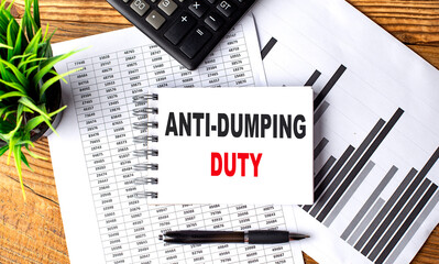 ANTI-DUMPING DUTY text on notebook on chart with calculator and pen