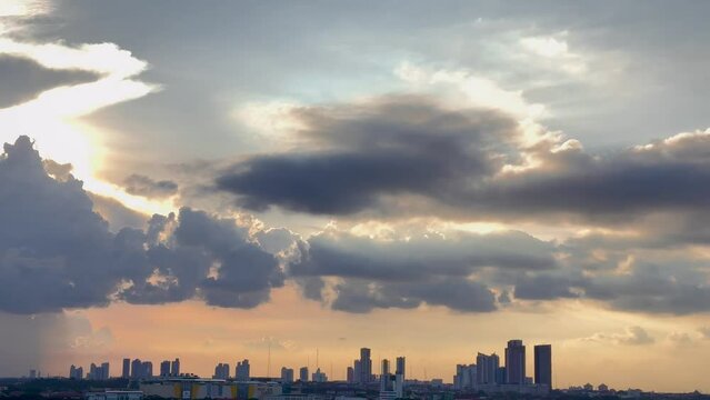 4K City Panoramic Video. Magnificent view of sunset sky with beautiful combination of blue sky colors, ember sun lights, and several unique floating clouds above the city downtown skyline silhouette s